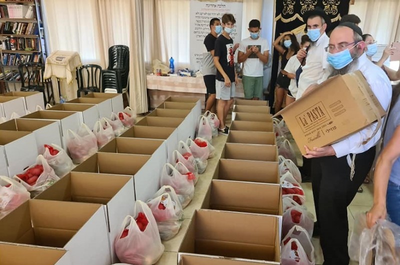 תמיכה לחג: שלוחי הרבי לצד מתנדבים, באריזת חבילות מזון לנזקקים לקראת ראש השנה, בבית חב