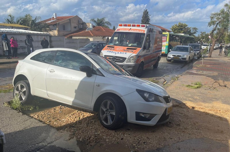 נזקי סופת 'כרמל': רכב נתקע בבור שנפער בכביש ברחוב מיכאל הלפרין בנתניה. גבר בן 25 פונה במצב קל לבית הרפואה 'לניאדו' בעיר (צילום: איחוד הצלה)