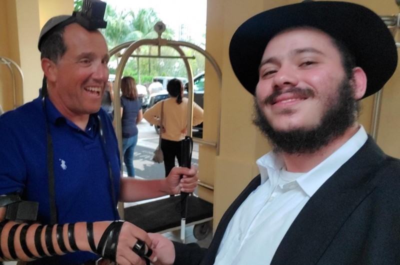 'והיו לטוטפות בין עיניך': ריצ'רד ברנשטיין שהתפרסם בעולם בעקבות מינויו לשופט בבית משפט העליון של מישיגן למרות היותו 'סגי נהור', מניח תפילין בהתרגשות יחד עם התמים אליהו עזאגווי