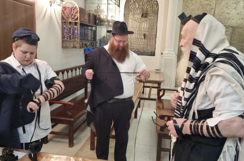 הבוקר בבית הכנסת בלשוי ברוניא במוסקבה שברוסיה: הנחת תפילין לבנו של ראש ישיבת מכון הר
