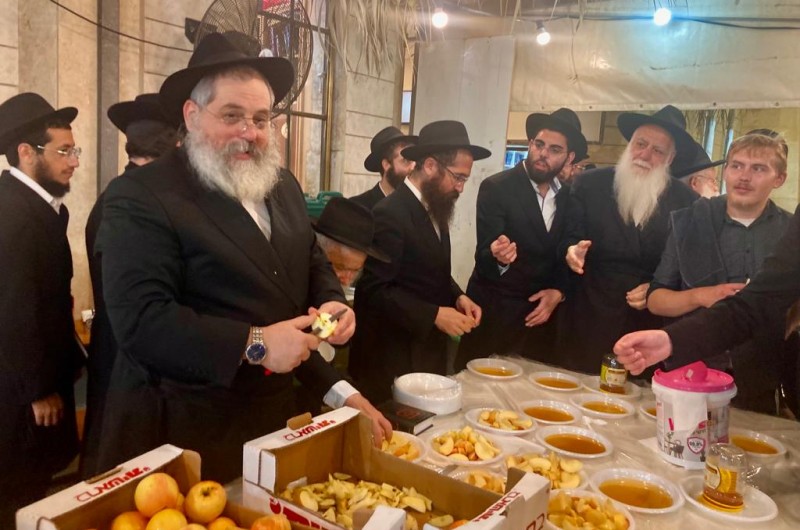 ר׳ בנימין ריבקין מגבאי בית כנסת ׳בית מנחם׳ מחלק כמידי שנה למתפללי בית הכנסת תפוח ודבש לאחר תהלים לליל הושענא רבא