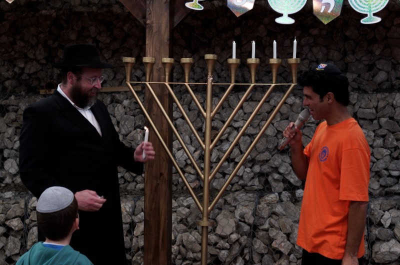 במהלך ההופעה: שחקן הילדים טל מוסרי בהדלקת נר חנוכה יחד עם הרב שמואל וולף משלוחי חב