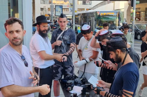 לב ישראל ער: צעירים מכל החוגים מניחים תפילין בתל אביב בדוכן שמאייש השליח במקום הרב עדי אלפנט