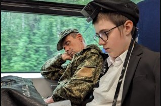 תלמיד 'חדר מנחם' במוסקבה, בתפילת שחרית על הרכבת לקוסטרמה, לצדו של חייל עייף מצבא רוסיה, השב מהמלחמה בחזית להפוגה קלה לביתו: