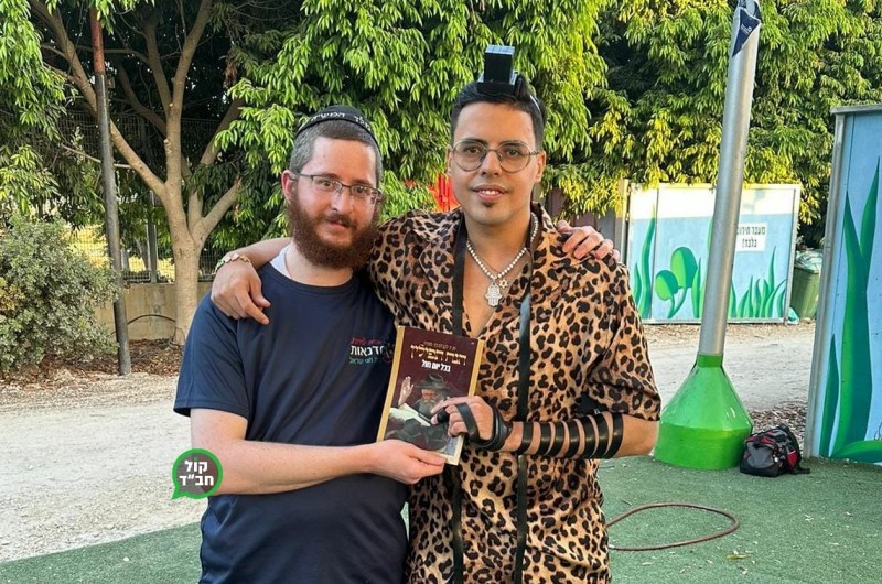 הזמר סטטיק בהנחת תפילין עם הת' שניאור זלמן נוימן, רגע לפני הופעה לנערי בר מצווה יתומים בסופרלנד במסגרת האירוע השנתי 