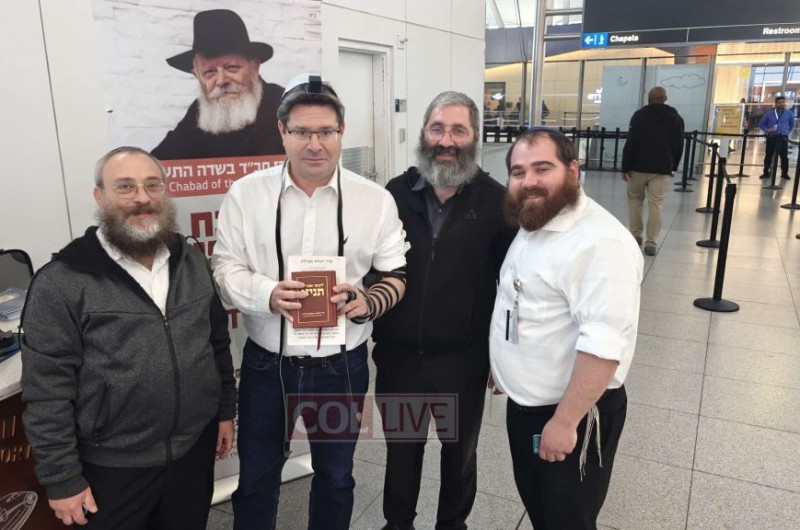 בדרכו לארץ-הקודש: הקונסול של ישראל בניו יורק - אופיר אקוניס ביקר בדוכן חב״ד בשדה התעופה קנדי, הניח תפילין עם השליח הרב יוסי ראפ וקיבל ספר תניא כהוקרה