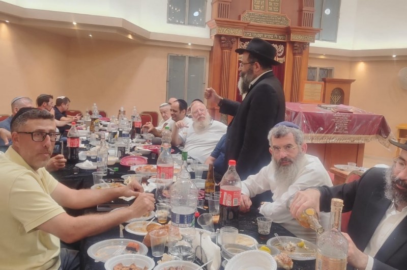 סביב שולחנות ערוכים: מתפללי בית הכנסת וחברי הקהילה בהתוועדות חג הגאולה י סביב שולחנות ערוכים: מתפללי בית הכנסת וחברי הקהילה בהתוועדות חג הגאולה י