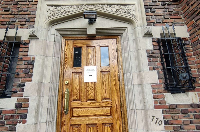 זמנית - אין כניסה לעוברים ושבים: שלט שנתלה דיווח על שיפוצים וצביעה בלובי הכניסה של 770 בניו יורק, ליד חדרו הקדוש של הרבי, על ידי בדק הבית בניהול הרב חיים ברוך הלברשטם