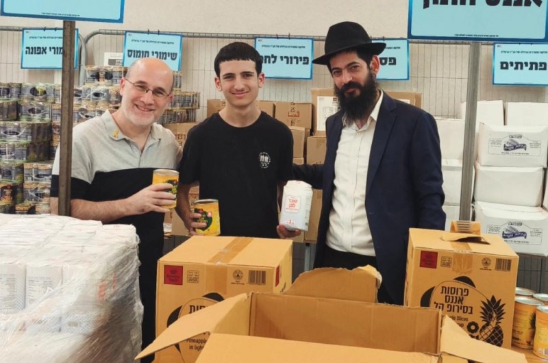 המצווה השנתית: חבר מועצת העיר הרצליה ודובר איגוד השופטים בהתאחדות הכדורגל - ירון עולמי, מסייע יחד עם בנו בהכנת חבילות מזון לנזקקים עם אנשי חב