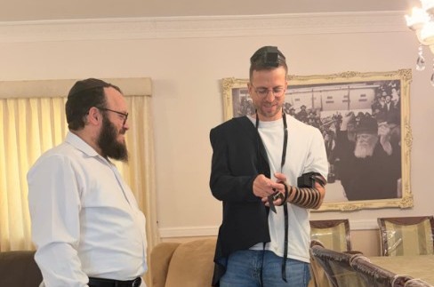 כתב חדשות 12 לענייני חרדים, אלי הירשמן, מניח תפילין יחד עם הרב שמואל אוירכמן מנהל קשרי ממשל מטעם אגודת חסידי חב״ד