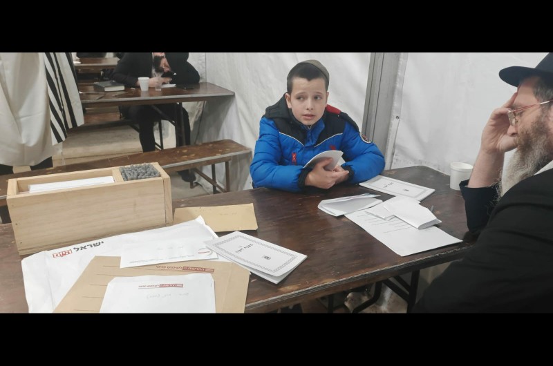 ר' מוני אנדר ובנו, השלוחים בתקשורת, בהכנה לפני הכניסה לאוהל הק'. ניתן לראות שעל השולחן מונחים פ