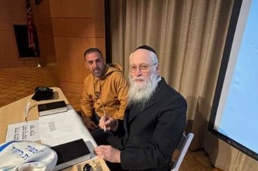 שורד השבי אלי שרעבי בכתיבת אותיות בספר תורה, לצד הסופר החב