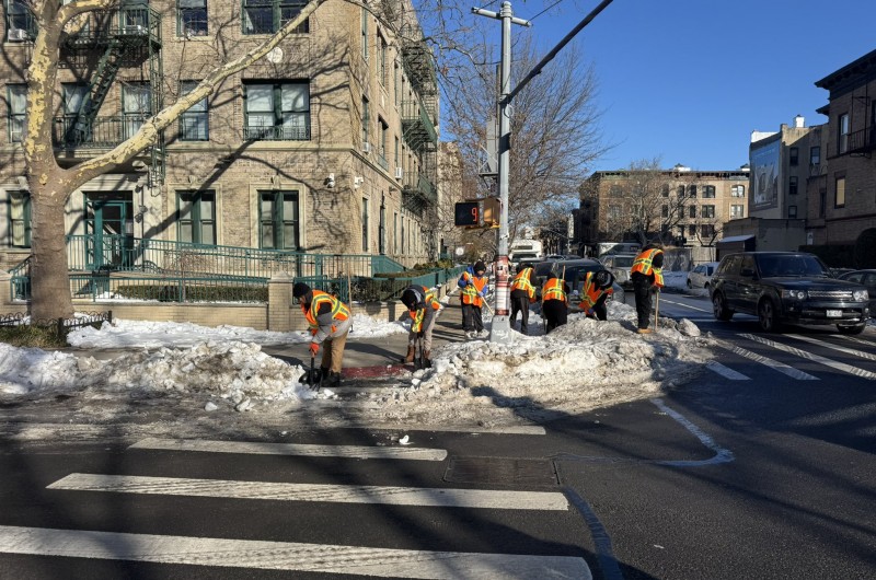 השמש זרחה אחרי הסופה: עובדי התברואה של עיריית ניו יורק מפנים את השלגים האחרונים שנותרו על המדרכות בקראון הייטס, בכדי שהולכי הרגל יוכלו ללכת בבטחה לדרכיהם