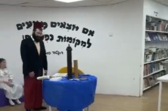 הת' שמואל בטשוילי מזכה בקריאת המגילה את תושבי שכונת כרמים בראשון לציון במרחב המוגן, תוך כדי האזעקות שנשמעות ברקע