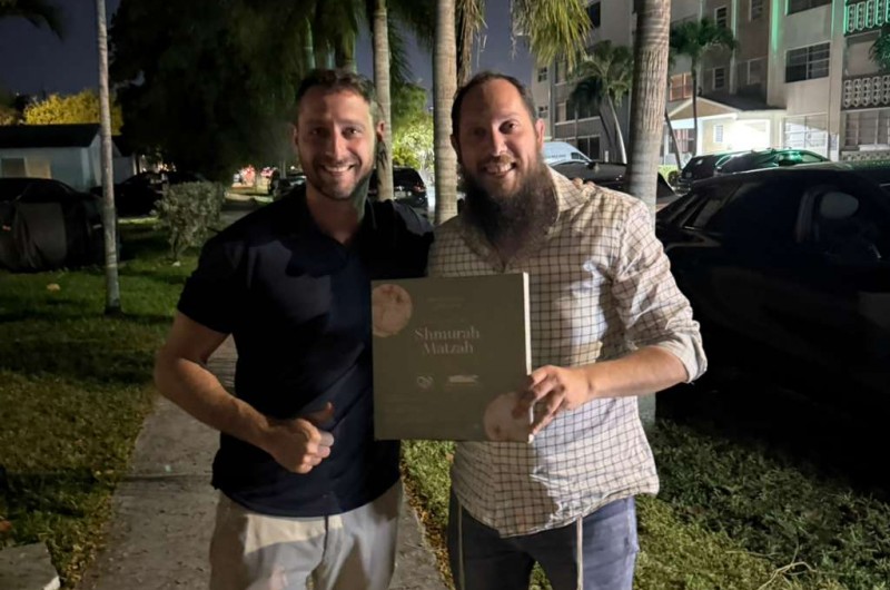 איש העסקים ר׳ דודי שגלוב מחלק מצה שמורה בעת ניחום אבלים אצל משפחת תעיזי באוהל האבלים