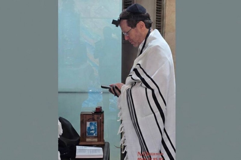 ערב יום הזיכרון: נשיא המדינה יצחק הרצוג בתפילת שחרית הבוקר בבית הנשיא בירושלים, כשלצידו קופת צדקה ועליה תמונת הרבי. צילום: מאיר דהן, COL 