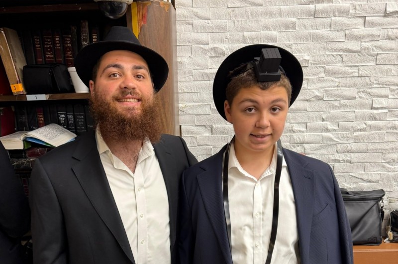 לא רק עם מפורסמים: התמים יוסי פארו מניו-יורק, שמזכה יהודים עשירים, בכירים ומפורסמים במצוות התפילין, בהנחת התפילין הראשונה של אחיו זלמי, בהיכל בית הכנסת ב-770 בקראון הייטס