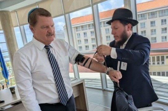 מייק עימאן, ראש הממשלה היהודי של מדינת ארובה שבאיים הקאריביים הנחשבת כטריטוריה הולנדית., מניח תפילין בלשכתו יחד עם שליח הרבי ומנהל בית חב